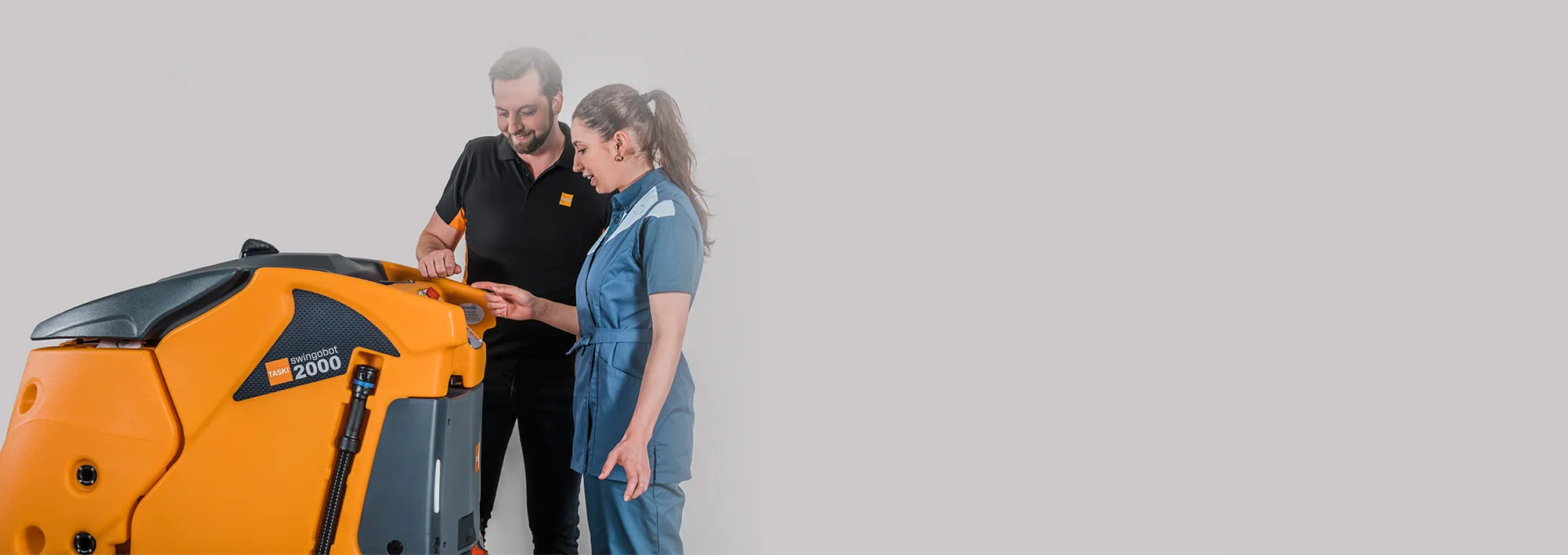 Técnico de Soltec asesorando a una clienta junto a una fregadora TASKI